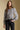 Front view of a woman wearing the Saltwater Luxe Brielle Top on a neutral background with black pants