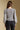 Back view of a woman wearing the Saltwater Luxe Brielle Top on a neutral background with arms at sides