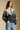 Front view of a woman wearing the Saltwater Luxe Cain Sweater with hand in pocket