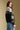 Side angle view of a woman wearing the Saltwater Luxe Cain Sweater looking over one shoulder