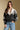 Front view of a woman wearing the Saltwater Luxe Cain Sweater with hand in pocket and jeans