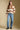 A full body front view of a woman wearing the Saltwater Luxe Cain Sweater on a neutral background