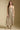 Front view of a woman wearing the Saltwater Luxe Calystah Midi Dress on a neutral background with matching tan boots