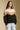 Front view of a woman wearing the Saltwater Luxe Camron Sweater on a neutral background with hands at sides