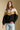 Front view of a woman wearing the Saltwater Luxe Camron Sweater on a neutral background with hand in pocket