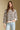 Front view of a woman wearing the Saltwater Luxe Camron Sweater on a neutral background with hand in pocket of jeans