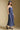Side angle view of a woman wearing the Salt Water Luxe Charlize Midi Dress on a neutral background with cap