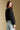 Back view of a woman wearing the Saltwater Luxe Jene Jacket on a neutral background looking over one shoulder