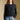 Front view of a woman wearing the Saltwater Luxe Verity Sweater on a neutral background with hand in pocket