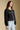 Side angle view of a woman wearing the Saltwater Luxe Jene Jacket on a neutral background with hands at sides