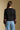 Back view of a woman wearing the Saltwater Luxe Darra Sweater on a neutral background with jeans