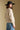 Back view of a woman wearing the Saltwater Luxe Dovere Sweater on a neutral background with arms at sides