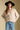Front view of a woman wearing the Saltwater Luxe Dovere Sweater on a neutral background with blue jeans and hat