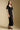 Front view of a woman wearing the Saltwater Luxe Drew Midi Dress and shoes on a neutral background 