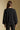 Back view of a woman wearing the Saltwater Luxe Ellyn Sweater on a neutral background