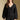 Front view of a woman wearing the Saltwater Luxe Ellyn Sweater on a neutral background with arms lowered and black pants