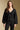 Front view of a woman wearing the Saltwater Luxe Ellyn Sweater on a neutral background with arms lowered and black pants