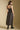 Back view of a woman wearing the Saltwater Luxe  Enza Midi Dress on a neutral background