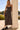 Front view of a woman wearing the Saltwater Luxe  Enza Midi Dress leaning on a column