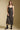 Front view of a woman wearing the Saltwater Luxe  Enza Midi Dress on a neutral background with hands at front