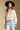 Front view of a woman wearing the Saltwater Luxe  Fiorra Sweater on a neutral background with flat brimmed black hat