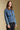 Side angle view of a woman wearing the Saltwater Luxe Garder Jacket on a neutral background with hands at sides