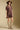 Side angle view of a woman wearing the Saltwater Luxe Ginna Mini Dress on a neutral background with hat and boots