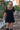 Front view of a woman wearing the Saltwater Luxe Ginna Mini Dress boots on a staircase