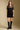 Front view of a woman wearing the Saltwater Luxe Ginna Mini Dress on a neutral background with boots