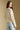 Back view of a woman wearing the Saltwater Luxe Hadlee Sweater on a neutral background with hands at sides