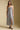 Front view of a woman wearing the Saltwater Luxe Harisyn Midi Dress on a neutral background with sneakers