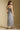 Back view of a woman wearing the Saltwater Luxe Harisyn Midi Dress on a neutral background