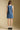 Back view of a woman wearing the Saltwater Luxe Haydin MinI Dress on a neutral background