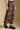 Side angle view of a woman wearing the Saltwater Luxe Ida Midi Skirt on a neutral background with shoes