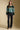 A full body front view of a woman wearing the Saltwater Luxe Isabeau Sweater on a neutral background