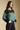 Side angle view of a woman wearing the Saltwater Luxe Isabeau Sweater on a neutral background with hands in pockets