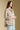 Side angle view of a woman wearing the Saltwater Luxe Ivah Jacket on a neutral background with hands clasped