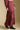 Side angle view of a woman wearing the Saltwater Luxe Jaycee Midi Skirt on a neutral background with top and boots