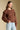 Side view of a woman wearing the Saltwater Luxe Jeri Sweater on a neutral background with one hand in pocket