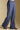 Side view of a woman wearing the Saltwater Luxe Joanie Pant on a neutral background with shoes