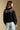 Back view of a woman wearing the Saltwater Luxe Joss Sweater on a neutral background