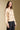 Side angle view of a woman wearing the Saltwater Luxe Joss Sweater on a neutral background with hands at sides