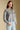 Side angle view of a woman wearing the Saltwater Luxe Joss Sweater on a neutral background with hands at sides