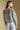 Back view of a woman wearing the Saltwater Luxe Joss Sweater on a neutral background`