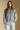 Front view of a woman wearing the Saltwater Luxe Joss Sweater on a neutral background with hand in pocket