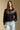 Front view of a woman wearing the Saltwater Luxe Joss Sweater on a neutral background with hand in pocket