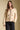 Front view of a woman wearing the Saltwater Luxe Joss Sweater on a neutral background with hand in pocket
