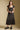 Front view of a woman wearing the Saltwater Luxe Junniper Midi Dress on a neutral background with black shoes