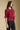 Side angle view of a woman wearing the Saltwater Luxe Kadie Top on a neutral background with hands at sides