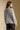 Back view of a woman wearing the Saltwater Luxe Kirra Sweater on a neutral background with jeans